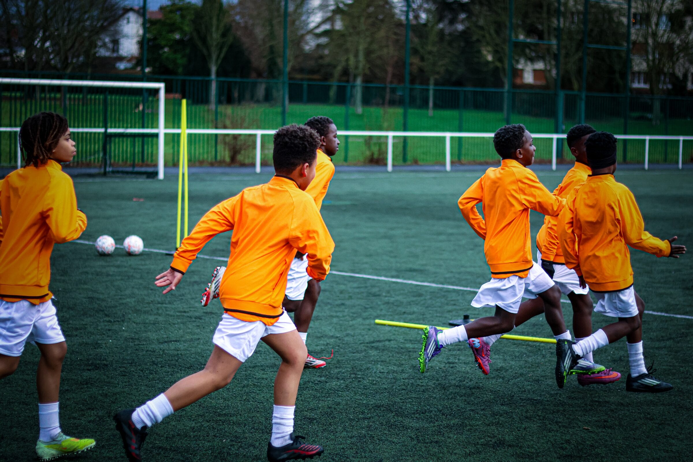 Groupe de jeunes joueurs AB Football Académie en sprint pendant l'échauffement