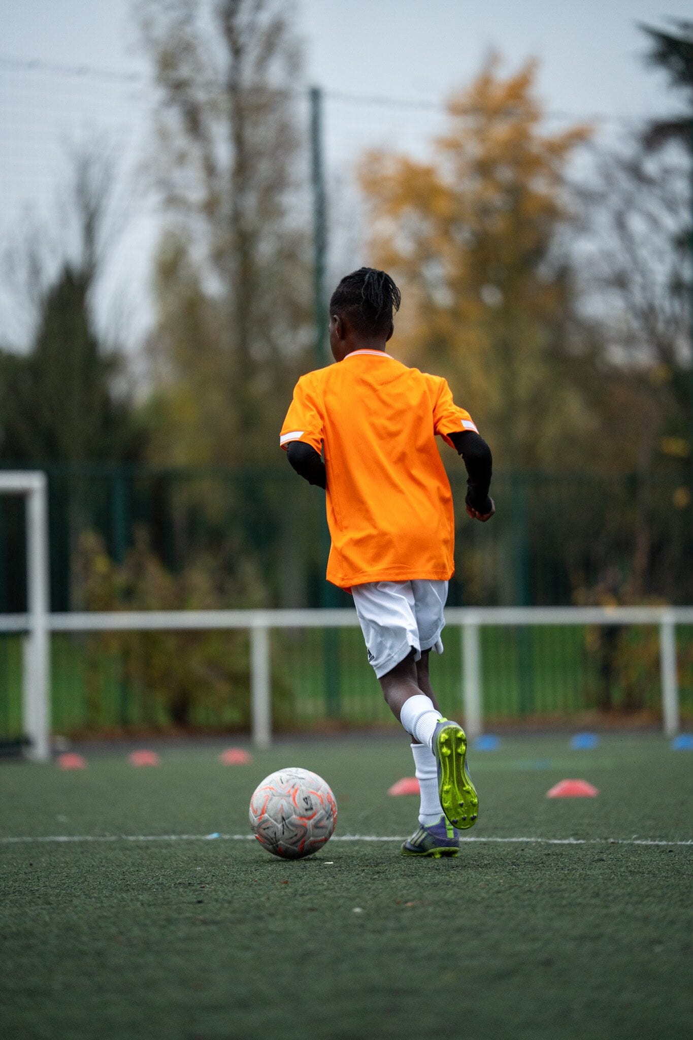 Jeune joueur AB Football Académie courant balle au pied en fin de journée