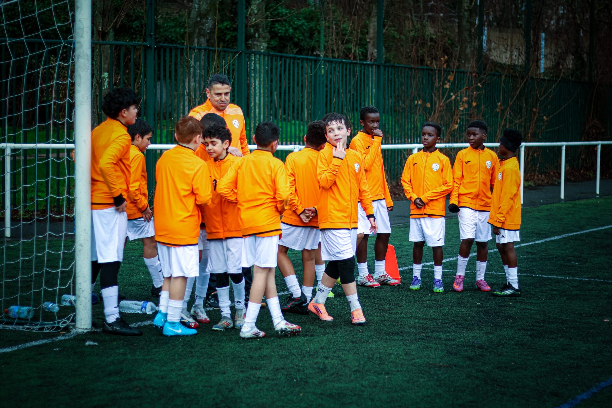 Le groupe de jeunes réuni autour de leur éducateur près du but, AB Football Académie